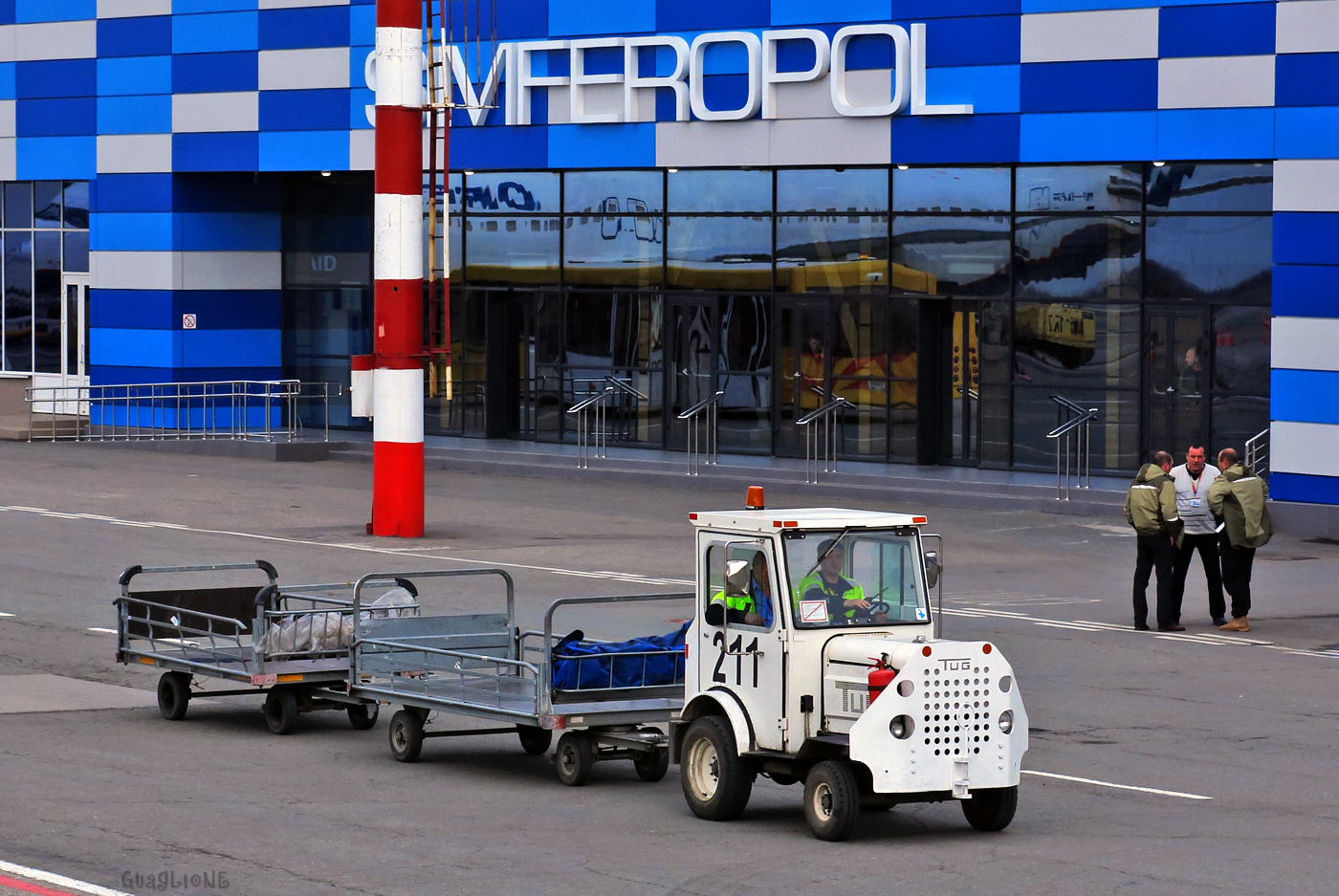 Аэродромный трактор TUG MA №211 с багажными тележками. Крым, аэропорт Симферополь