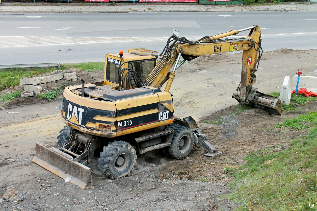 Колесный экскаватор Caterpillar M315. Długosza/Zagłębia Dąbrowskiego, Сосновец, Польша